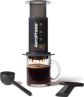 AeroPress vista frontal con vaso preparado, destaca la extracción limpia