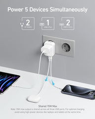 Anker adaptador en uso en habitación con laptop y smartphone cargando al mismo tiempo