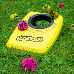 Koosh juego en césped con niños lanzando y sonriendo