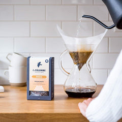 La Colombe granos vertiéndose en molinillo, frescura lista para moler