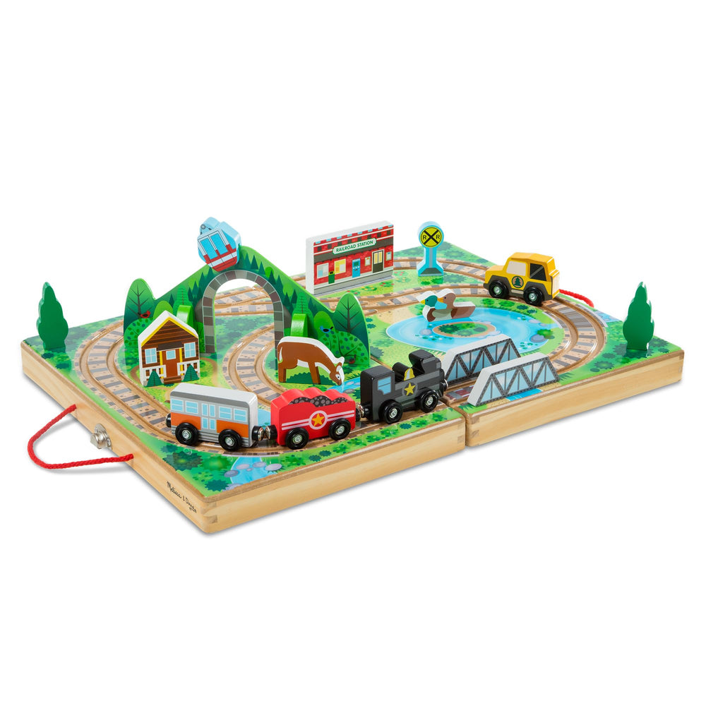 Melissa & Doug estuche abierto mostrando vías y escena, juego fácil de transportar