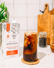 Milkadamia junto a taza y caja para comparar tamaño y uso práctico