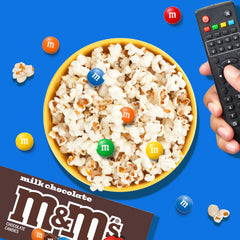 M&M'S caja en mano para comparar tamaño práctico y portátil