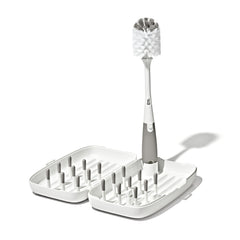 OXO Tot front view of compact travel drying rack showing organized bottles and pegs