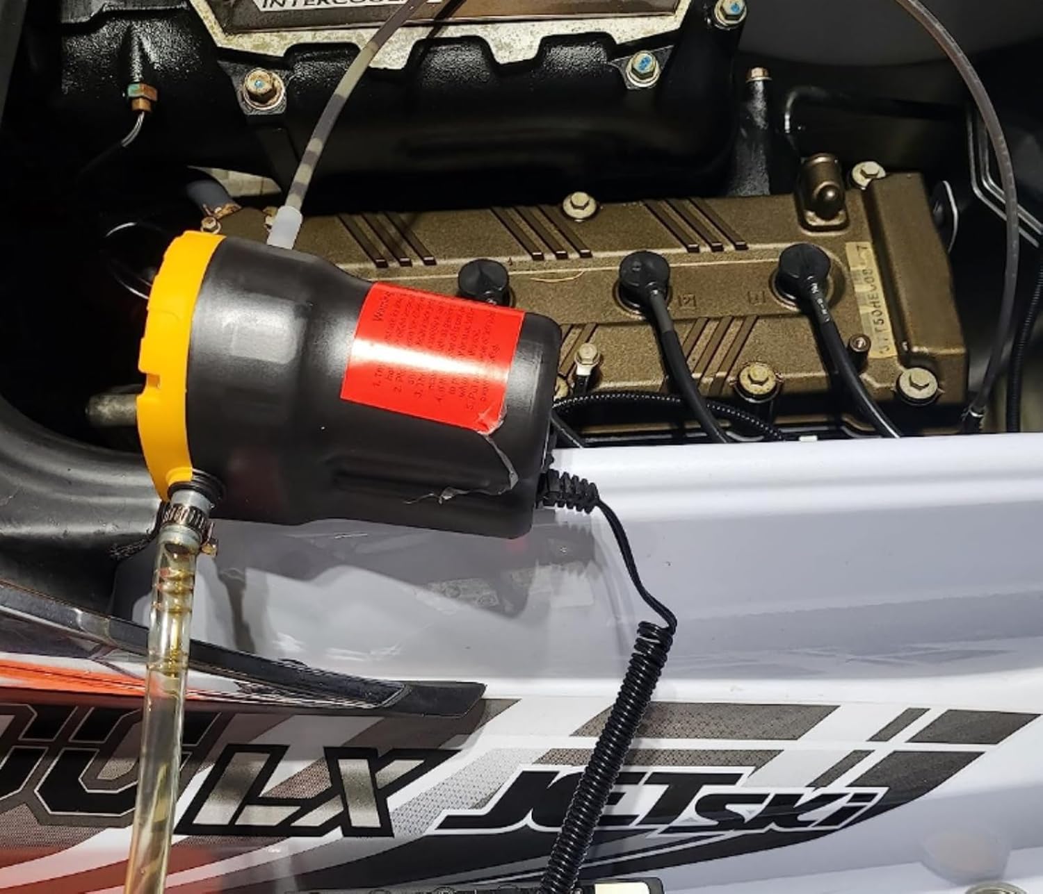 Amarine Made pump in use under car hood enabling clean oil removal on site