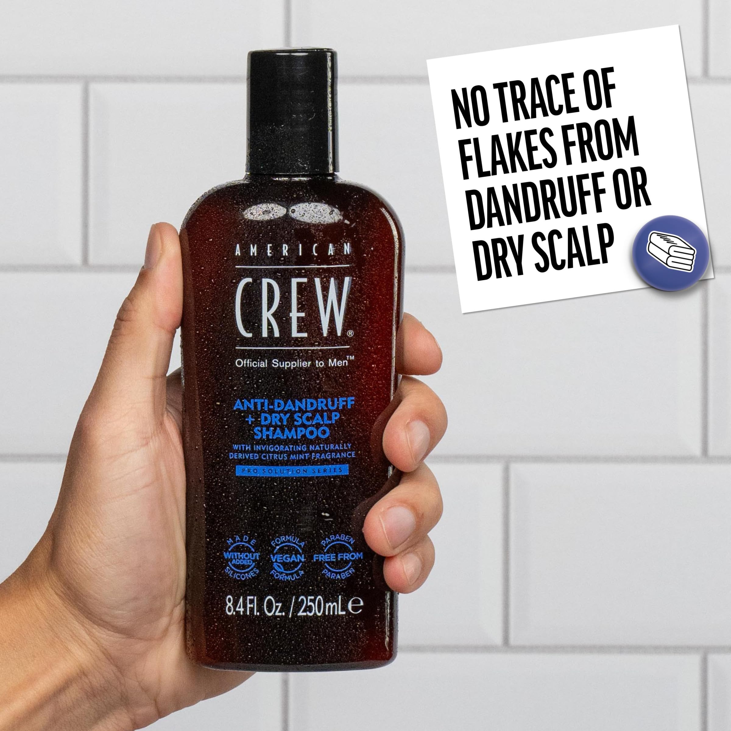 American Crew botella 8.4 fl oz comparada con mano para referencia de tamaño