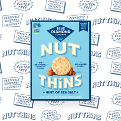 Comparación de tamaño de una galleta Nut-Thins con una mano para porciones prácticas