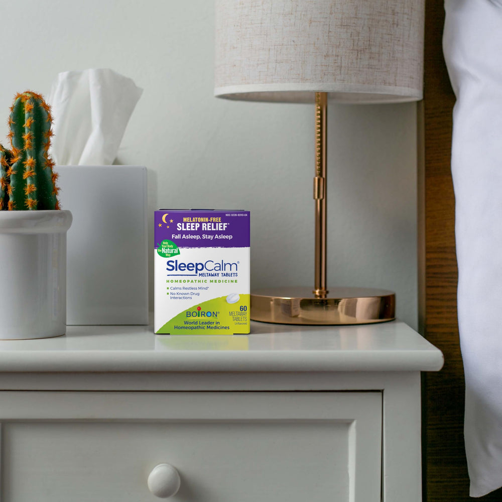 Boiron SleepCalm botella abierta con tabletas visibles para uso nocturno