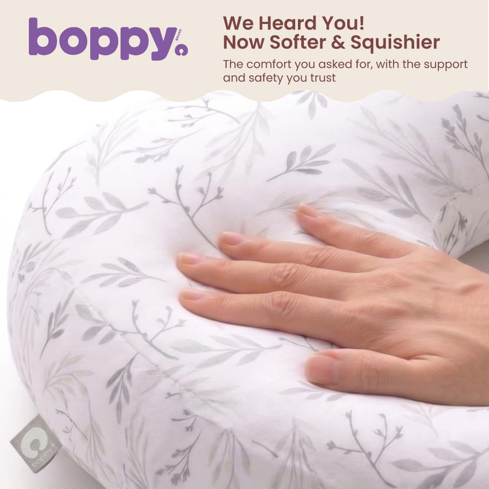 Boppy comparación de tamaño junto a una mano para escala clara