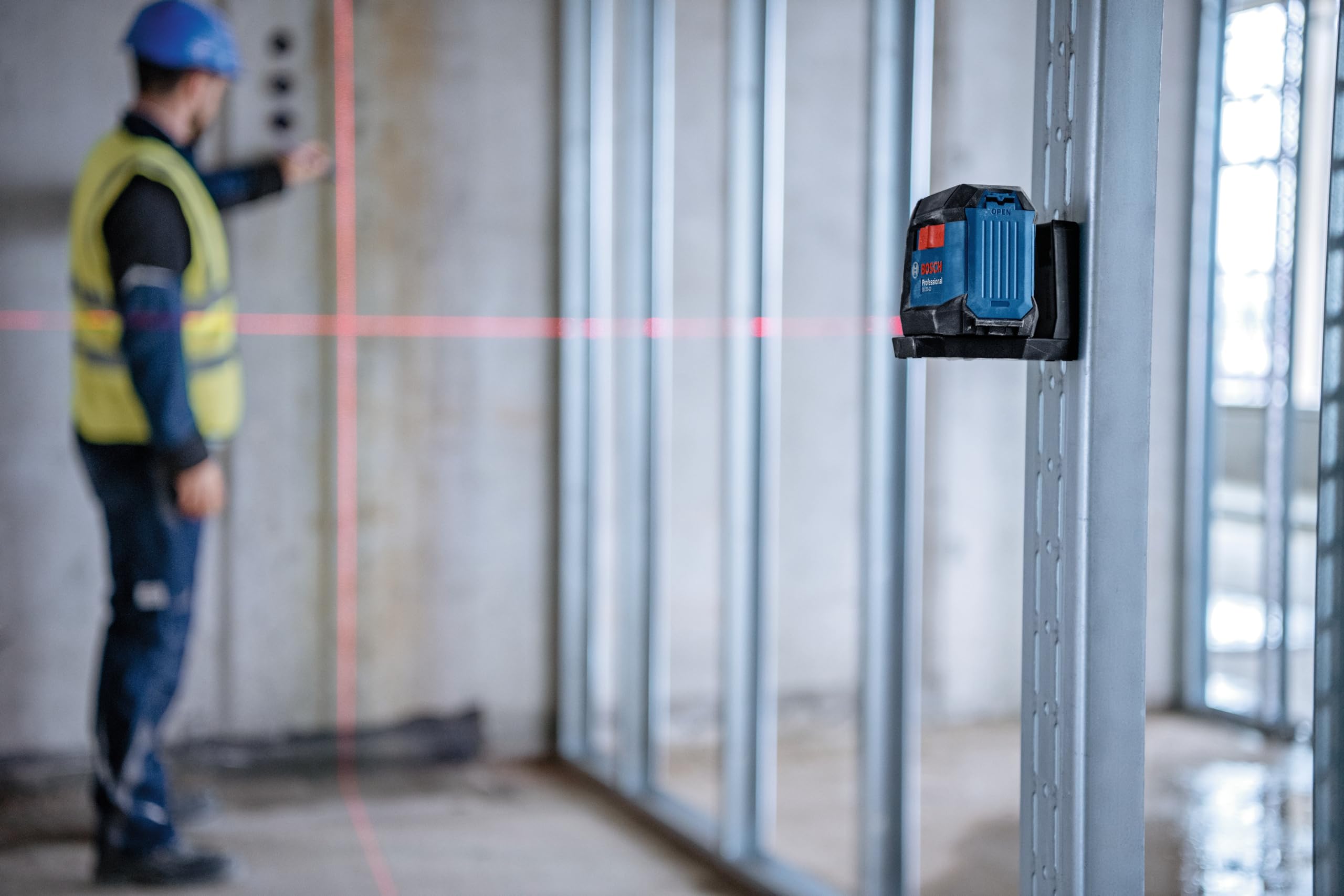 Bosch GLL50-20 en obra con salpicaduras de agua demostrando resistencia IP55