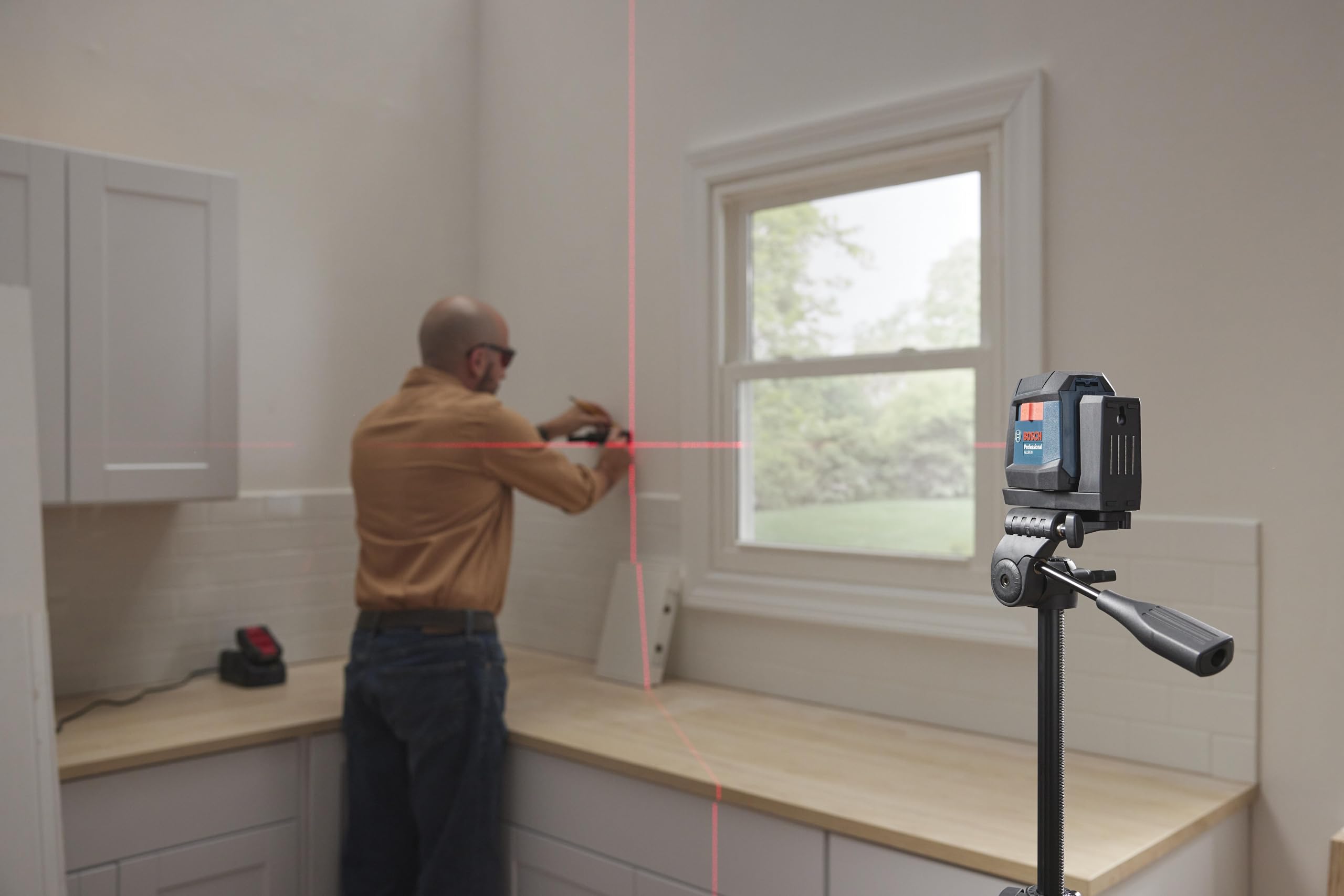 Bosch GLL50-20 comparación de tamaño con una mano para escala compacta