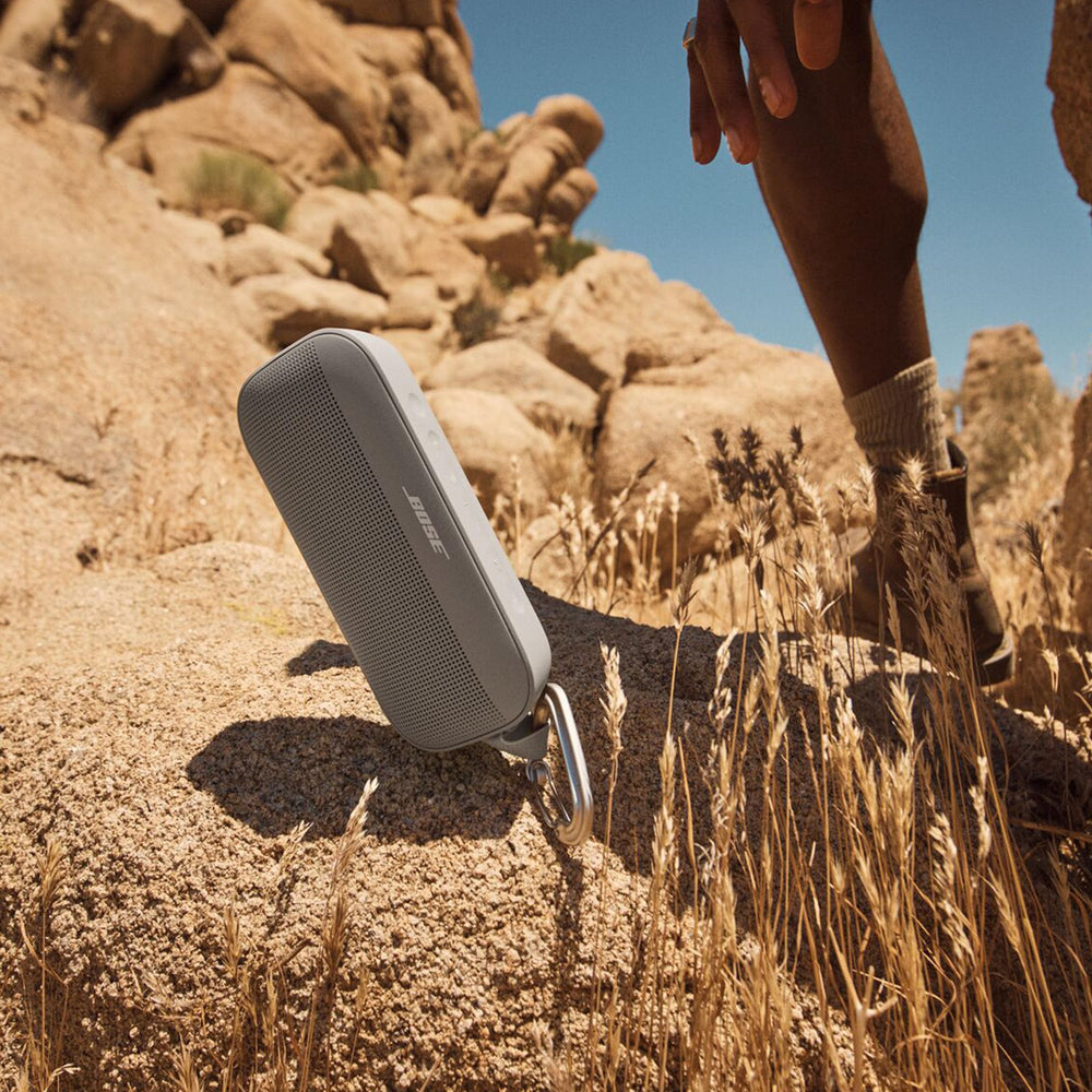 Bose SoundLink Flex en la playa con gente, ofrece sonido nítido para reuniones al aire libre