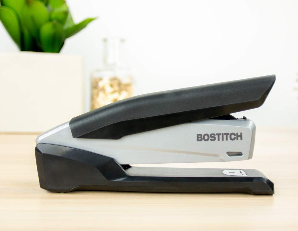 Bostitch INP20 abierta 180 grados clavando papeles en un tablero de anuncios