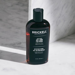 Brickell envase 4oz comparado con una mano para referencia de tamaño