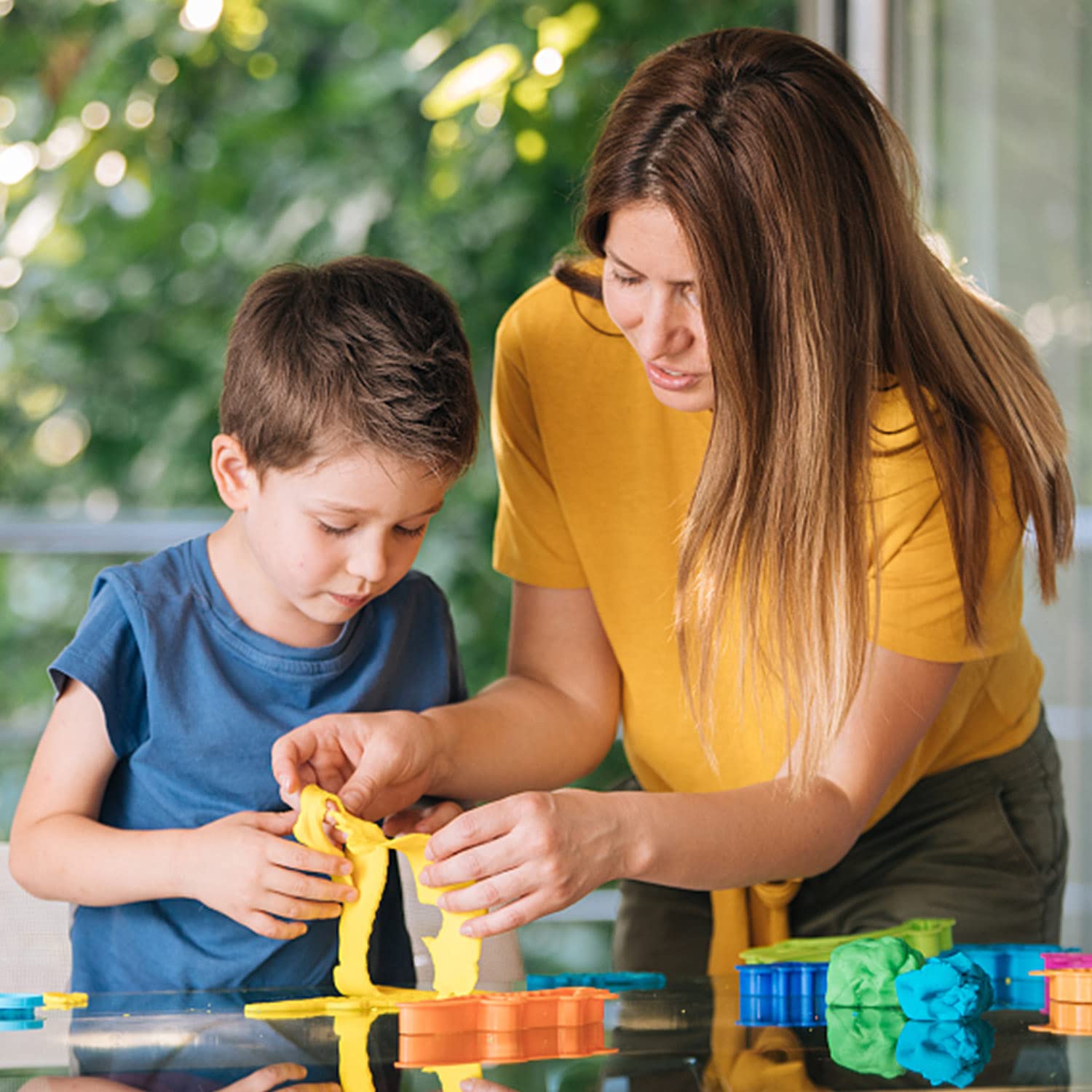 ESSENSON familia creando figuras en mesa fomentando creatividad conjunta