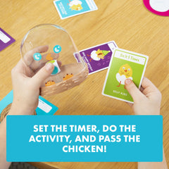 Exploding Kittens Chicken Shaker junto a manos para comparar tamaño y facilidad de agarre
