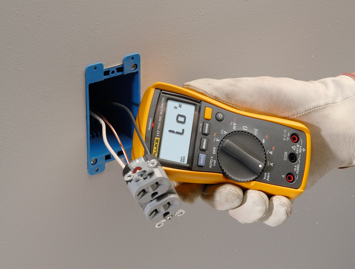 Fluke 117 junto a una mano para comparar tamaño y portabilidad