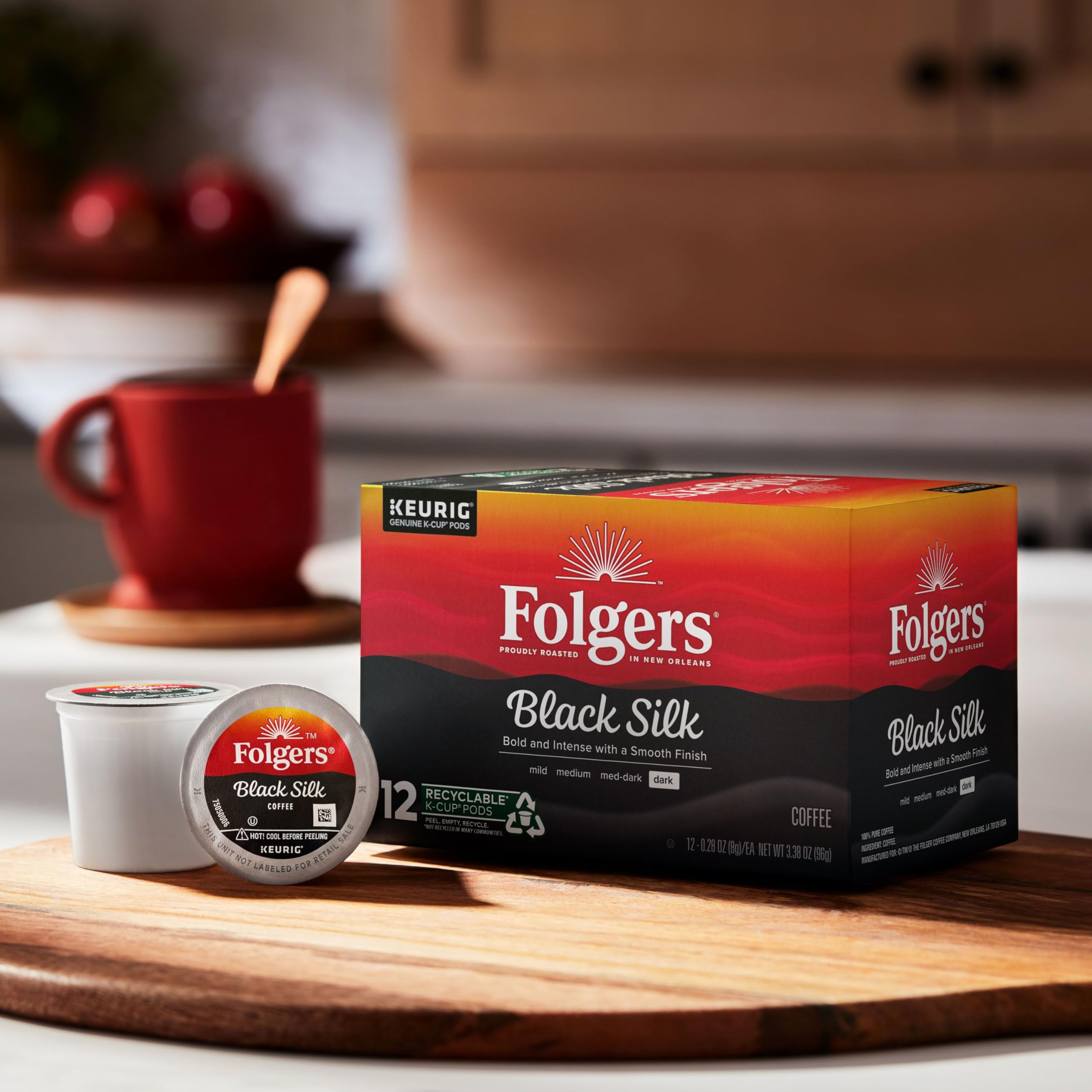 Folgers Black Silk cápsula junto a una taza para mostrar tamaño real