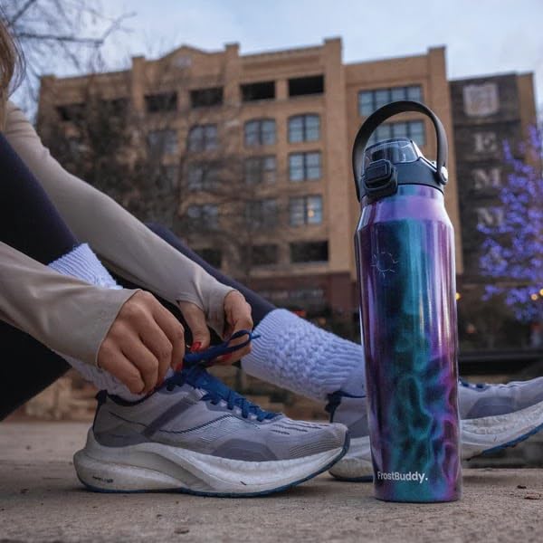Frost Buddy botella en gimnasio junto a toalla para hidratación rápida