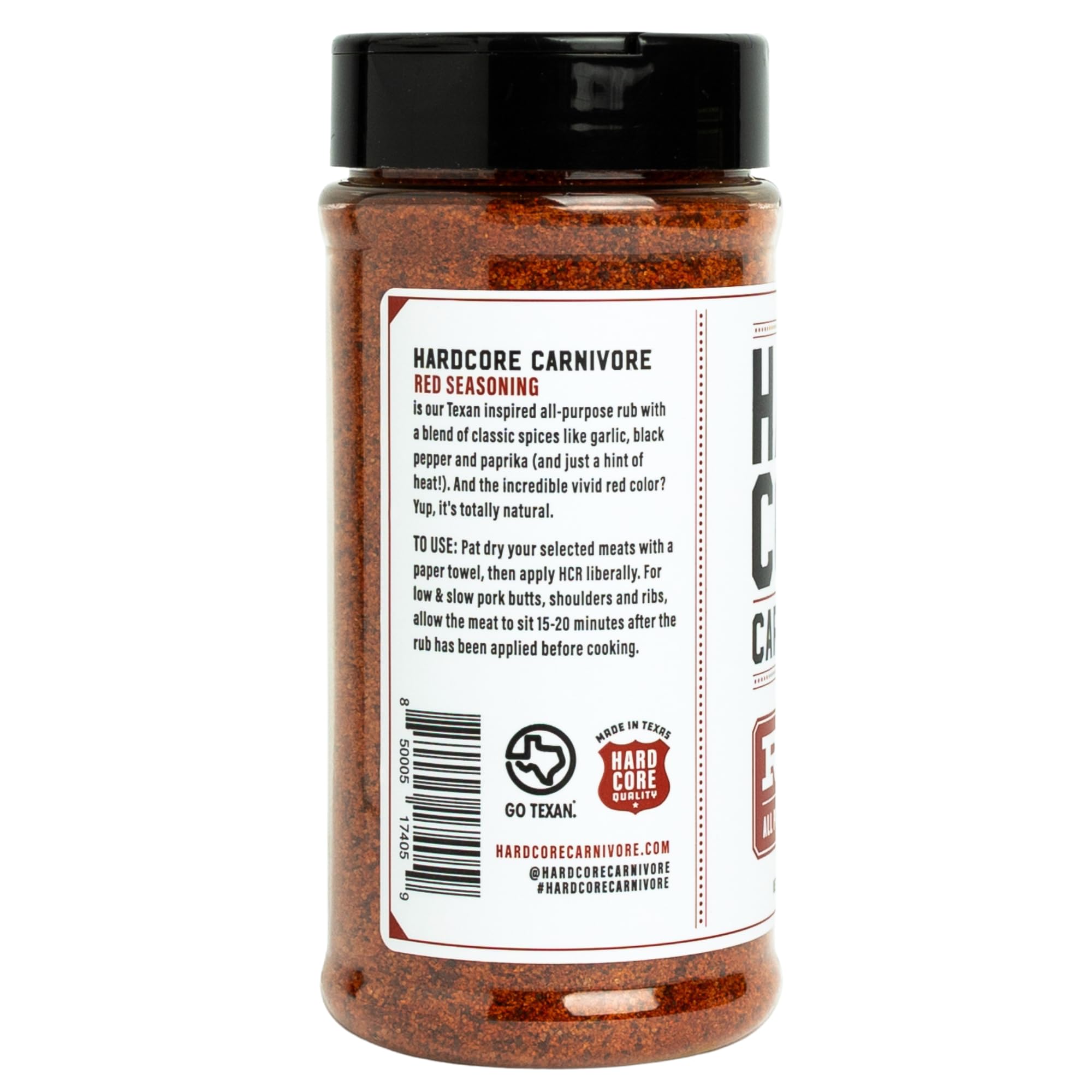 Escena de parrilla con botella Hardcore Carnivore Red al lado de carnes asándose, uso práctico