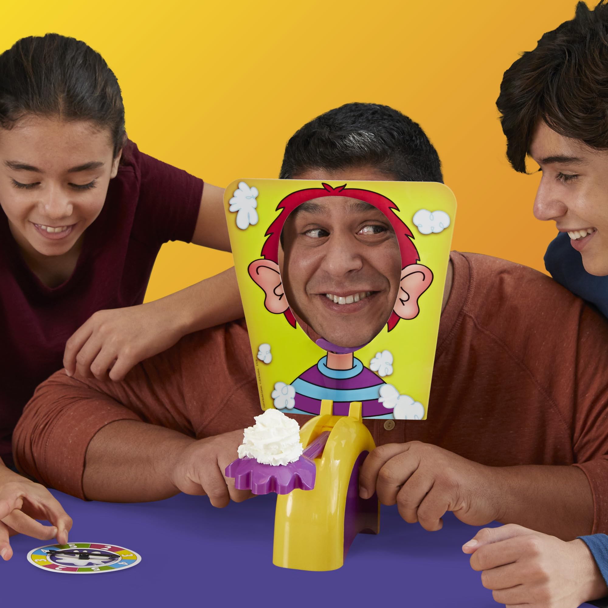 Hasbro Gaming familia jugando alrededor de la mesa, fomenta unión y risas
