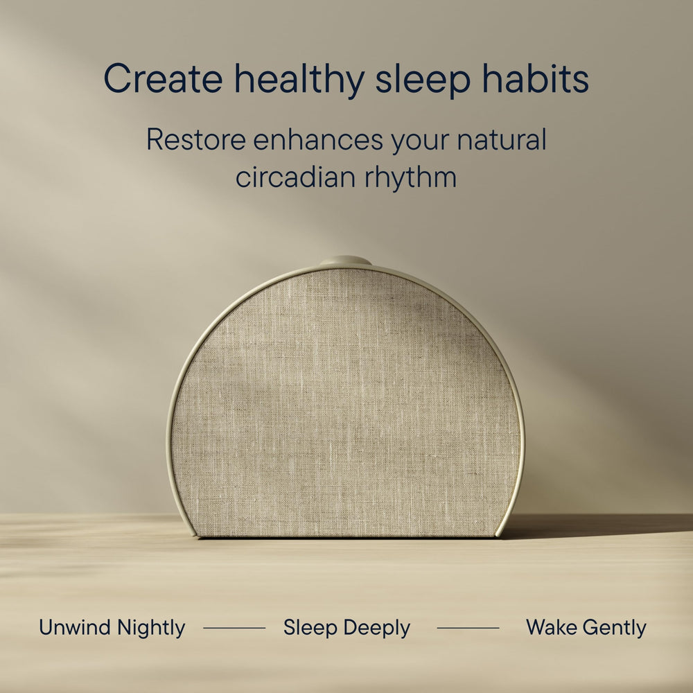 Hatch Baby Restore 3 junto a una lámpara y libro para comparación de tamaño