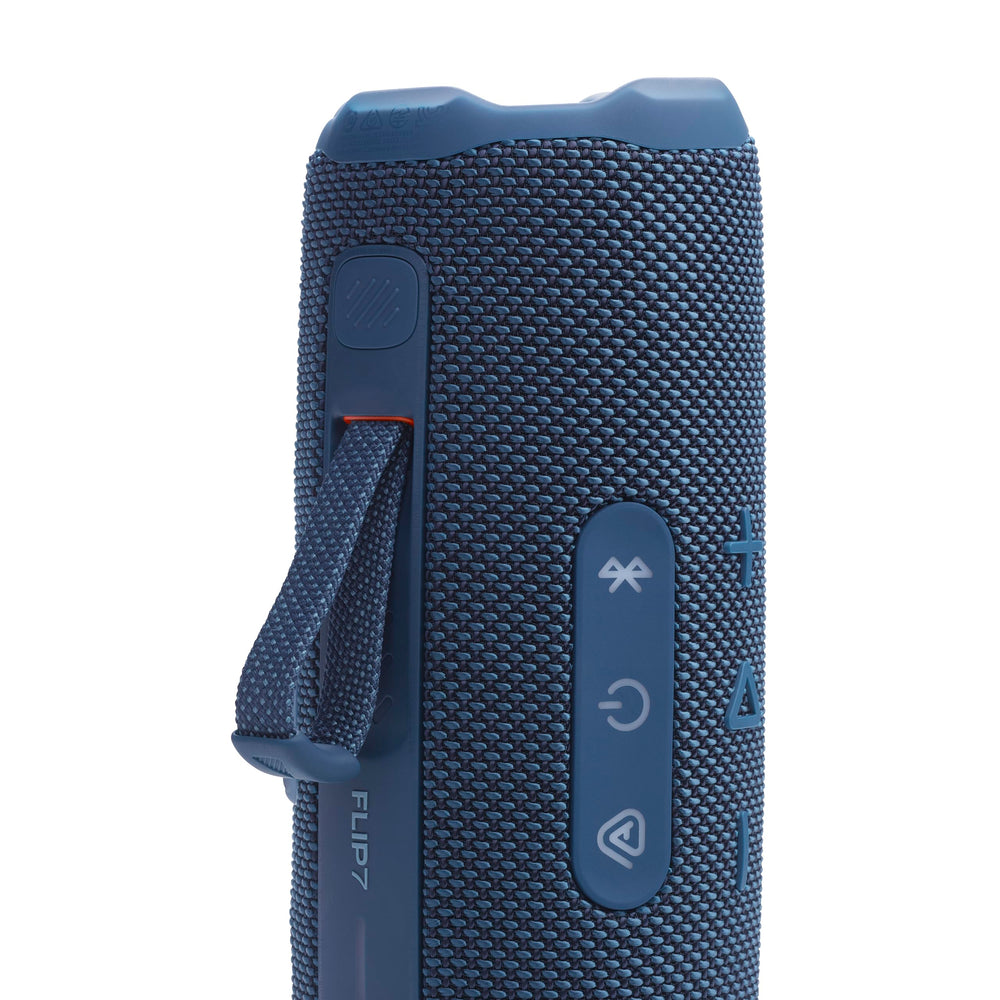 JBL Flip 7 en la playa ilustrando uso exterior y resistencia