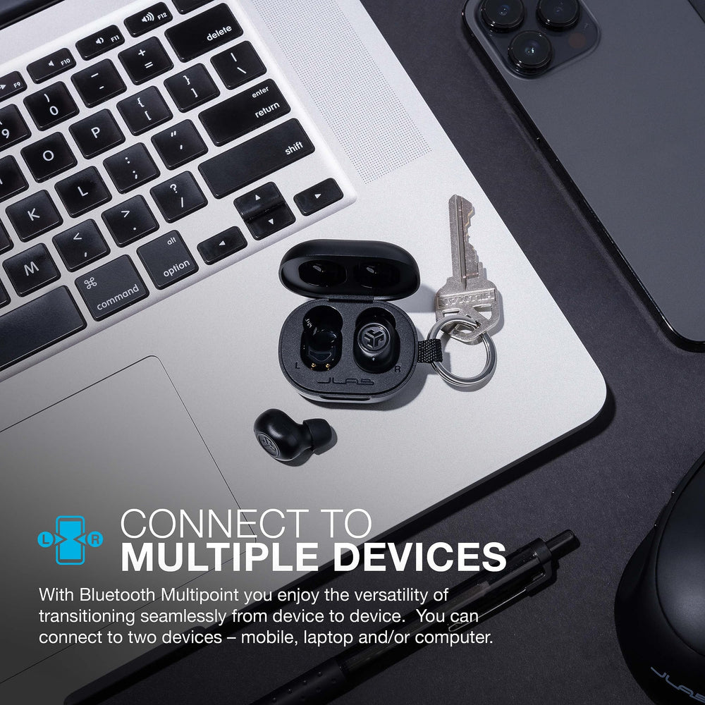 JLab JBuds Mini estuche abierto junto a una moneda para comparar tamaño