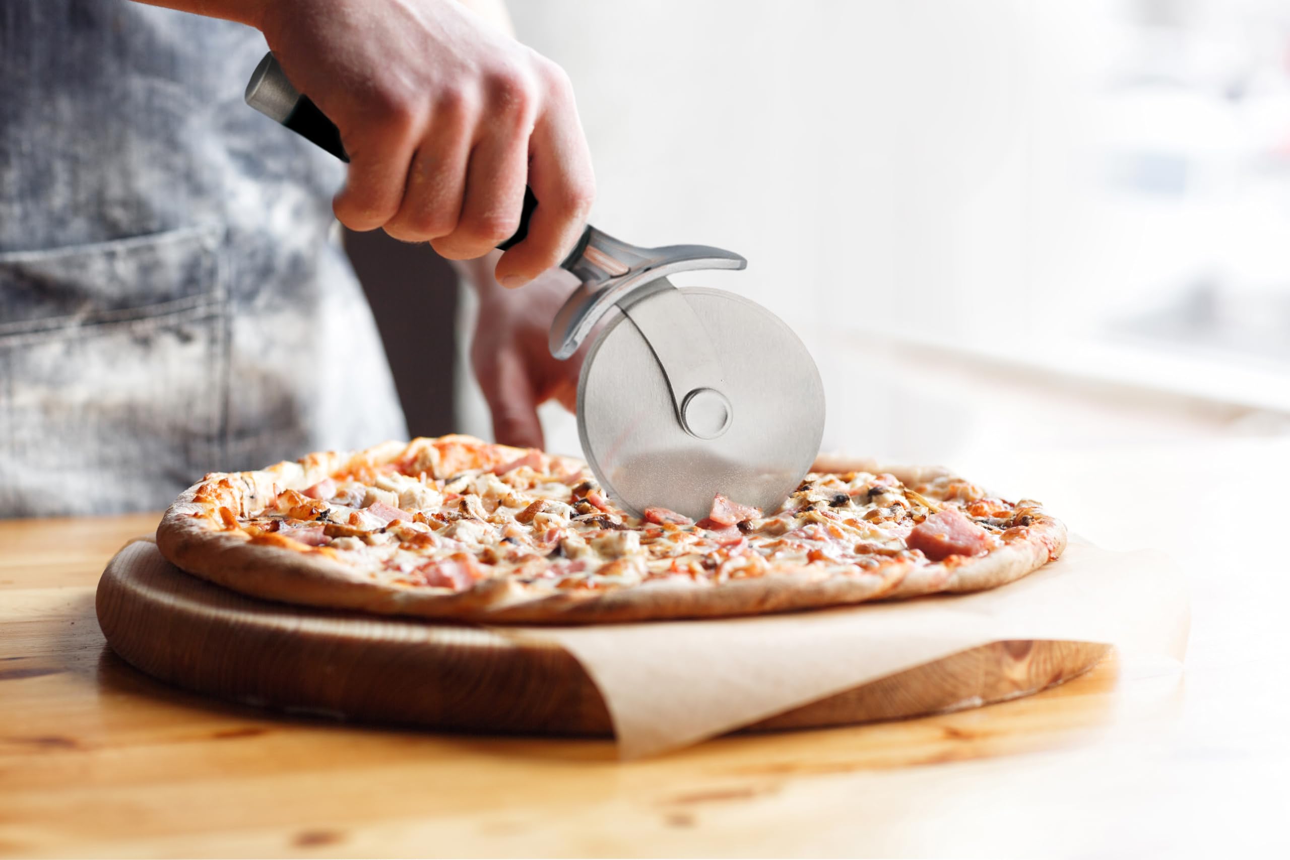 KitchenAid cortador en uso cortando pizza manteniendo toppings intactos