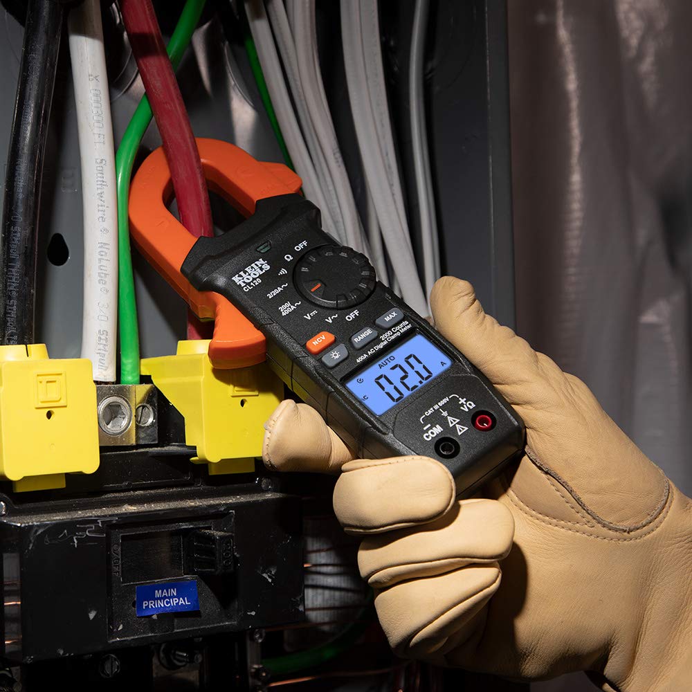 Klein Tools CL120 en uso dentro de cuadro eléctrico, facilita mediciones de corriente y tensión