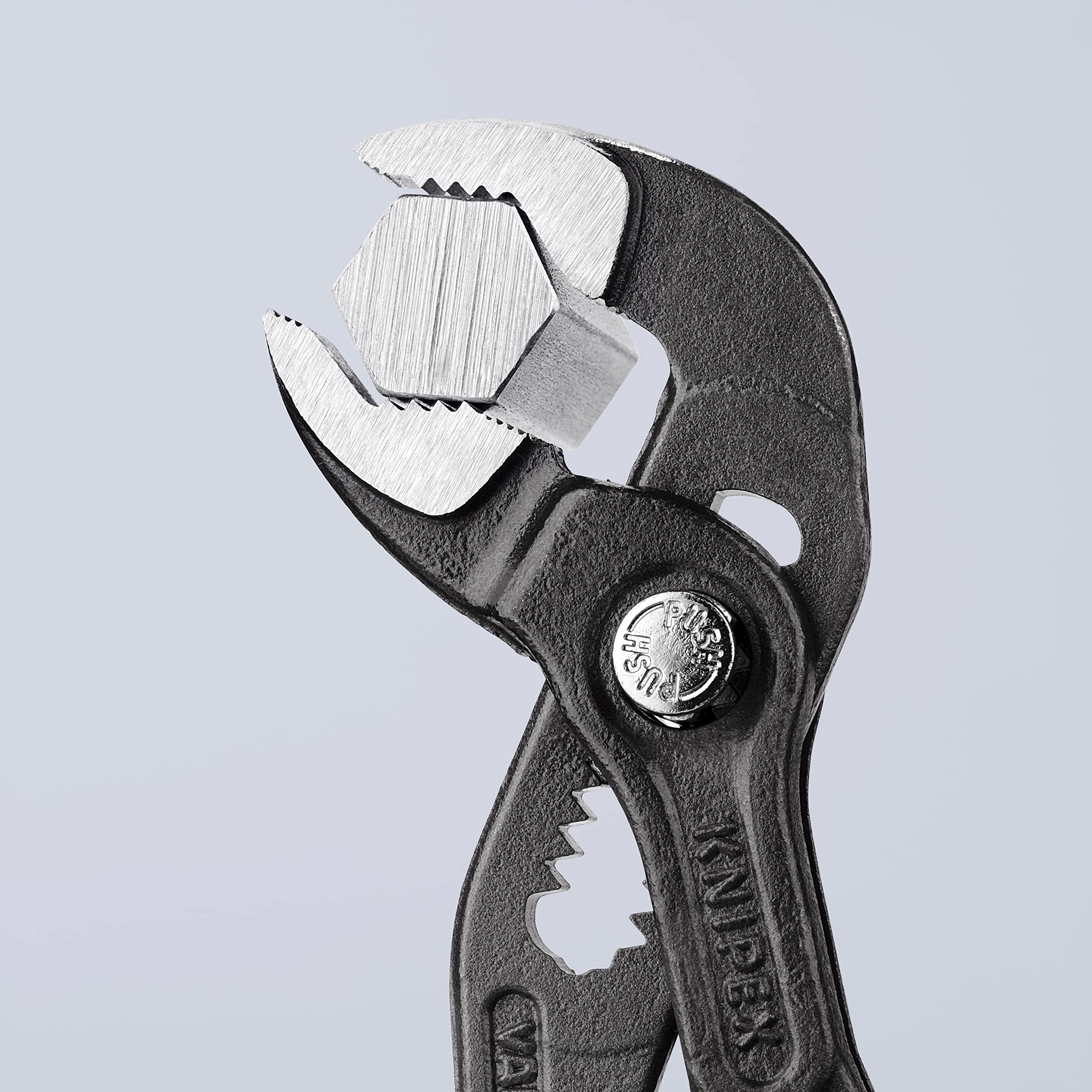 KNIPEX Cobra en uso sobre un tubo demostrando bloqueo seguro