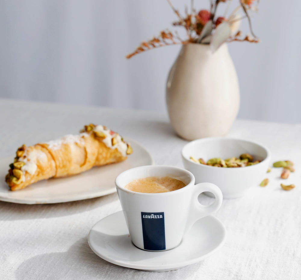 Lavazza taza servida con accesorios, presenta experiencia de degustación completa