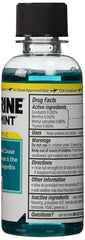 Listerine Cool Mint travel bottle in hand demonstrating portable size and quick freshening benefit