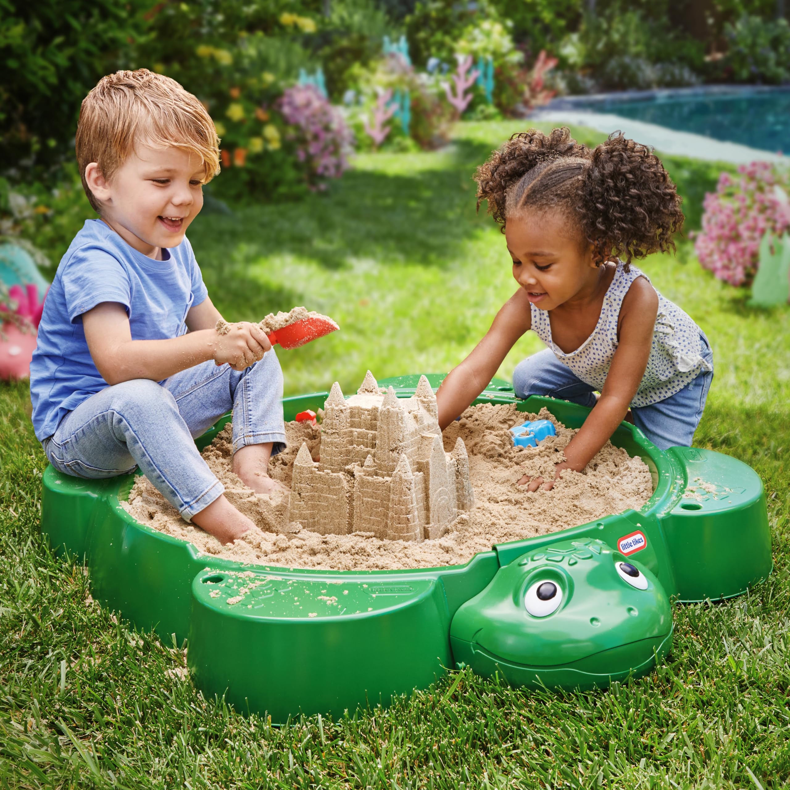 Little Tikes arenero con tapa abierta mostrando espacio amplio para arena y juguetes