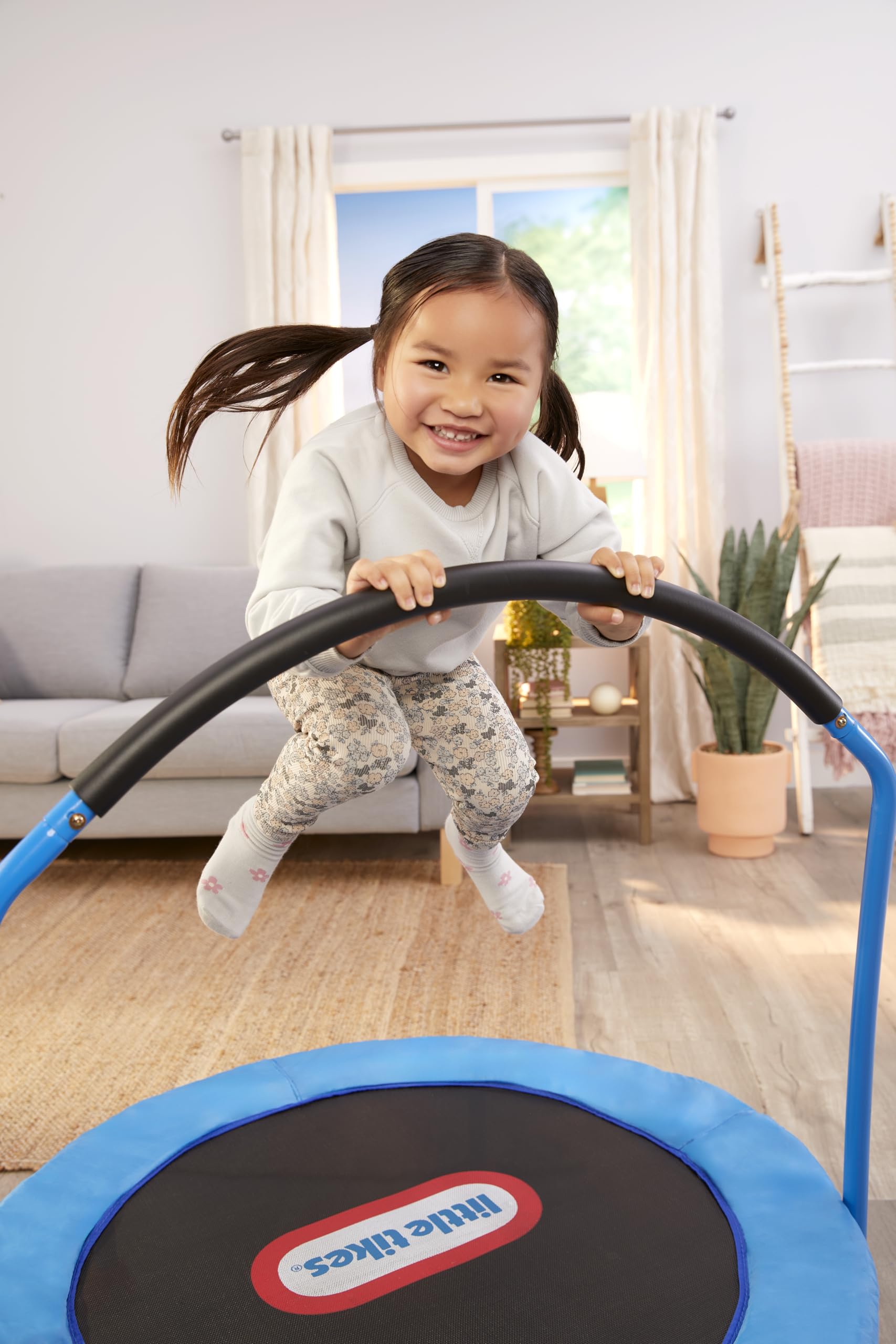 Little Tikes trampolín junto a silla para visualizar tamaño y escala