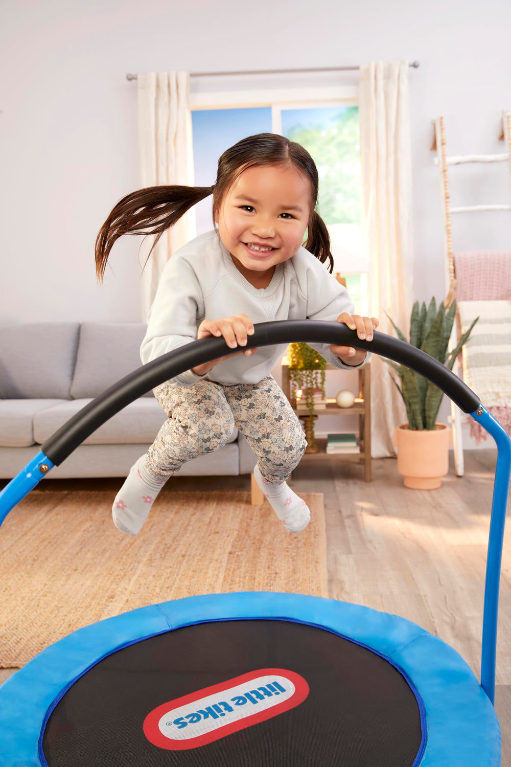 Little Tikes trampolín junto a silla para visualizar tamaño y escala