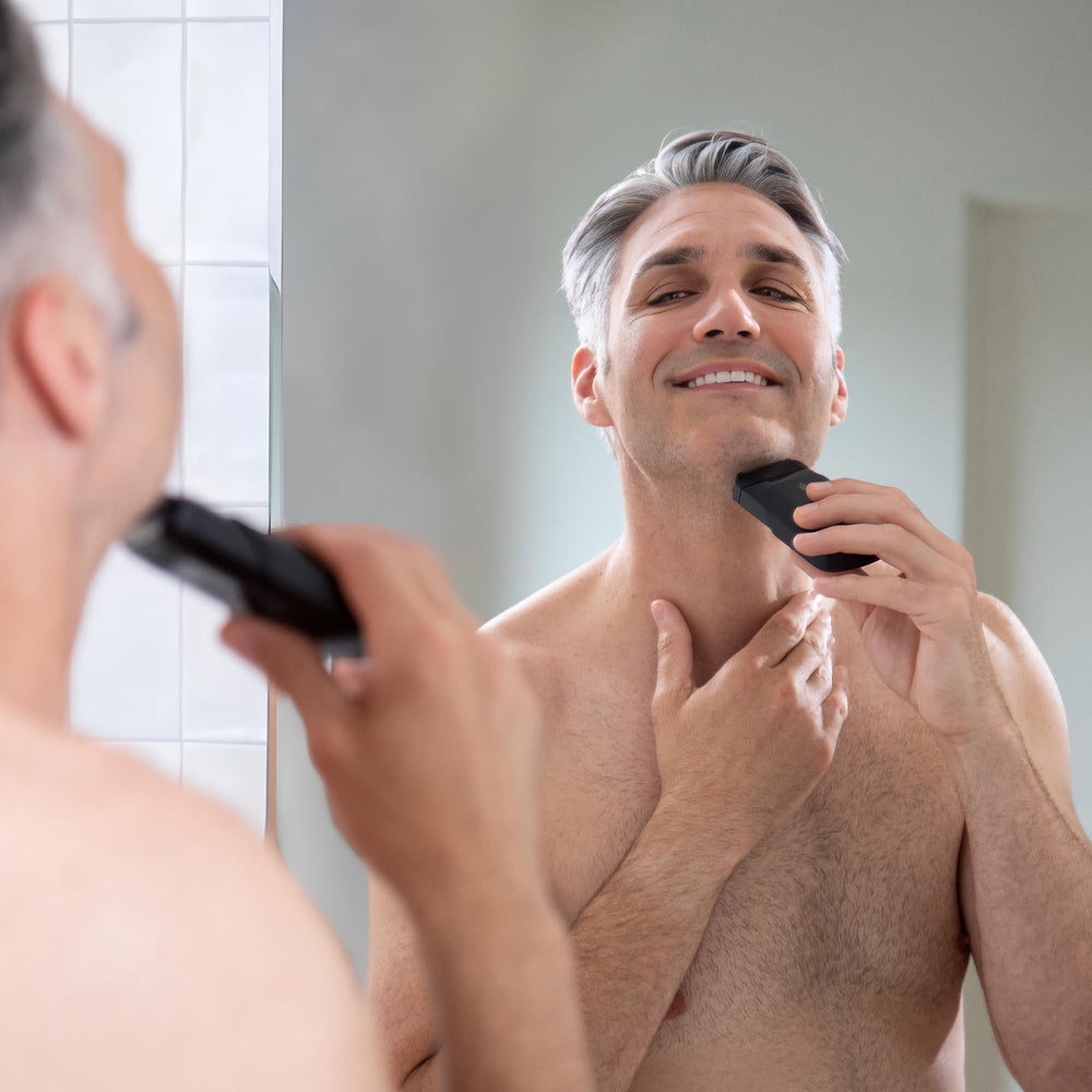 MANSCAPED dentro de un neceser de viaje representando portabilidad
