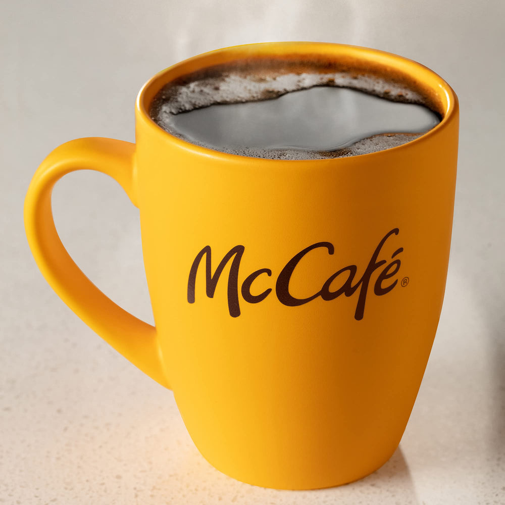 McCafé brewed cup with beans in background evoking balanced medium roast
