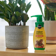 Miracle-Gro aplicando alimento líquido a plantas en sala, favorece follaje
