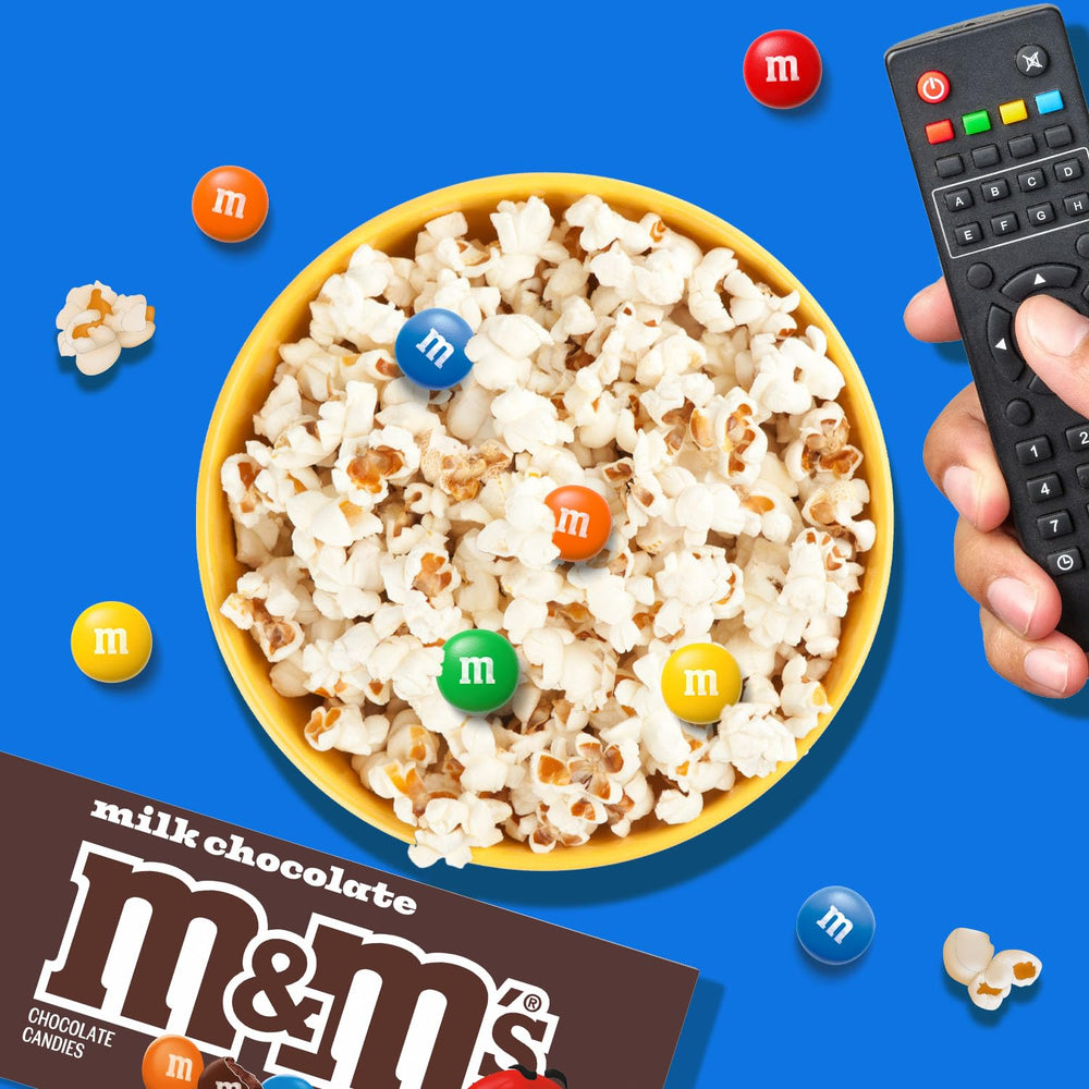 M&M'S caja en mano para comparar tamaño práctico y portátil