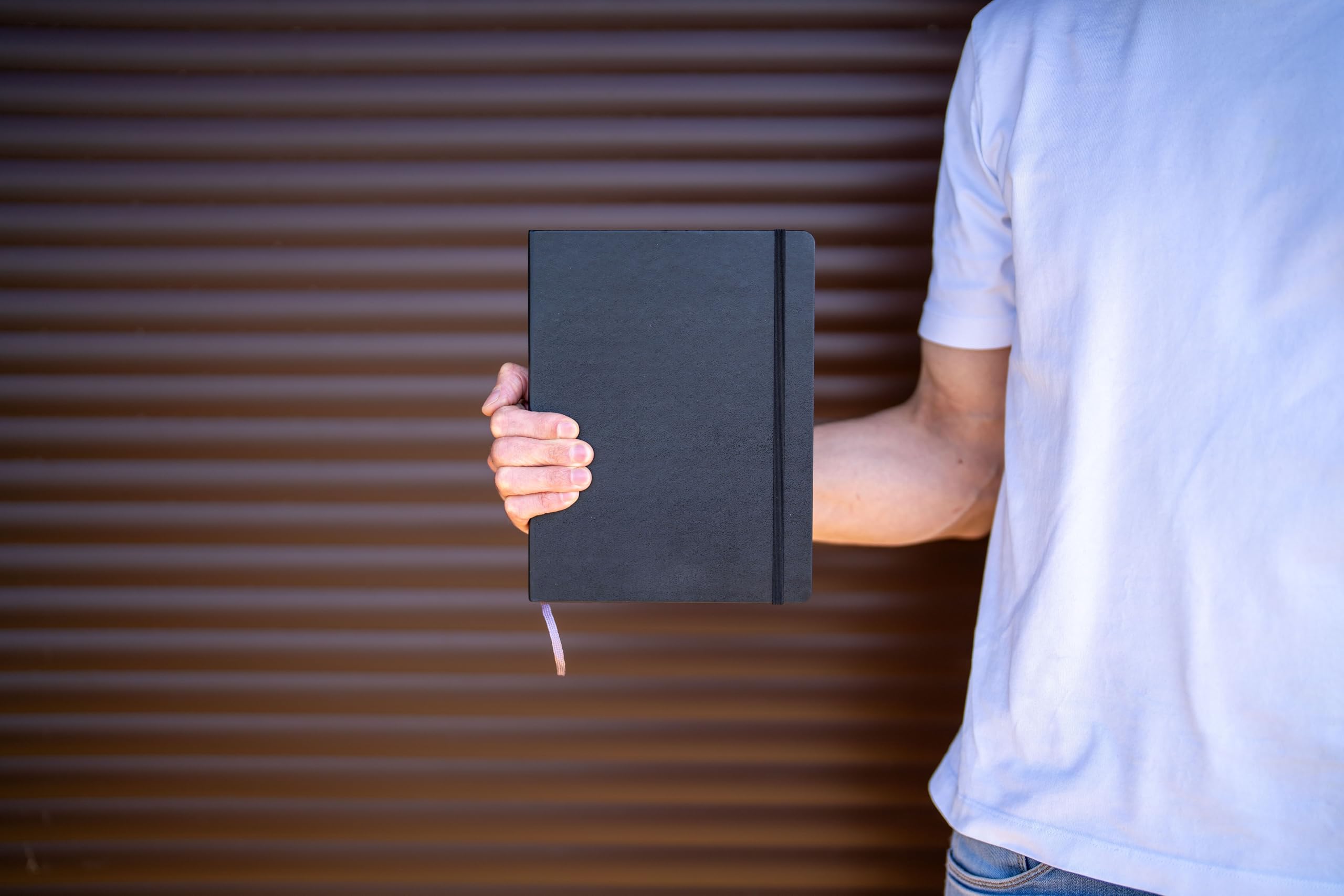 Cuaderno Moleskine en mesa de café y mochila, uso en viaje y estilo diario