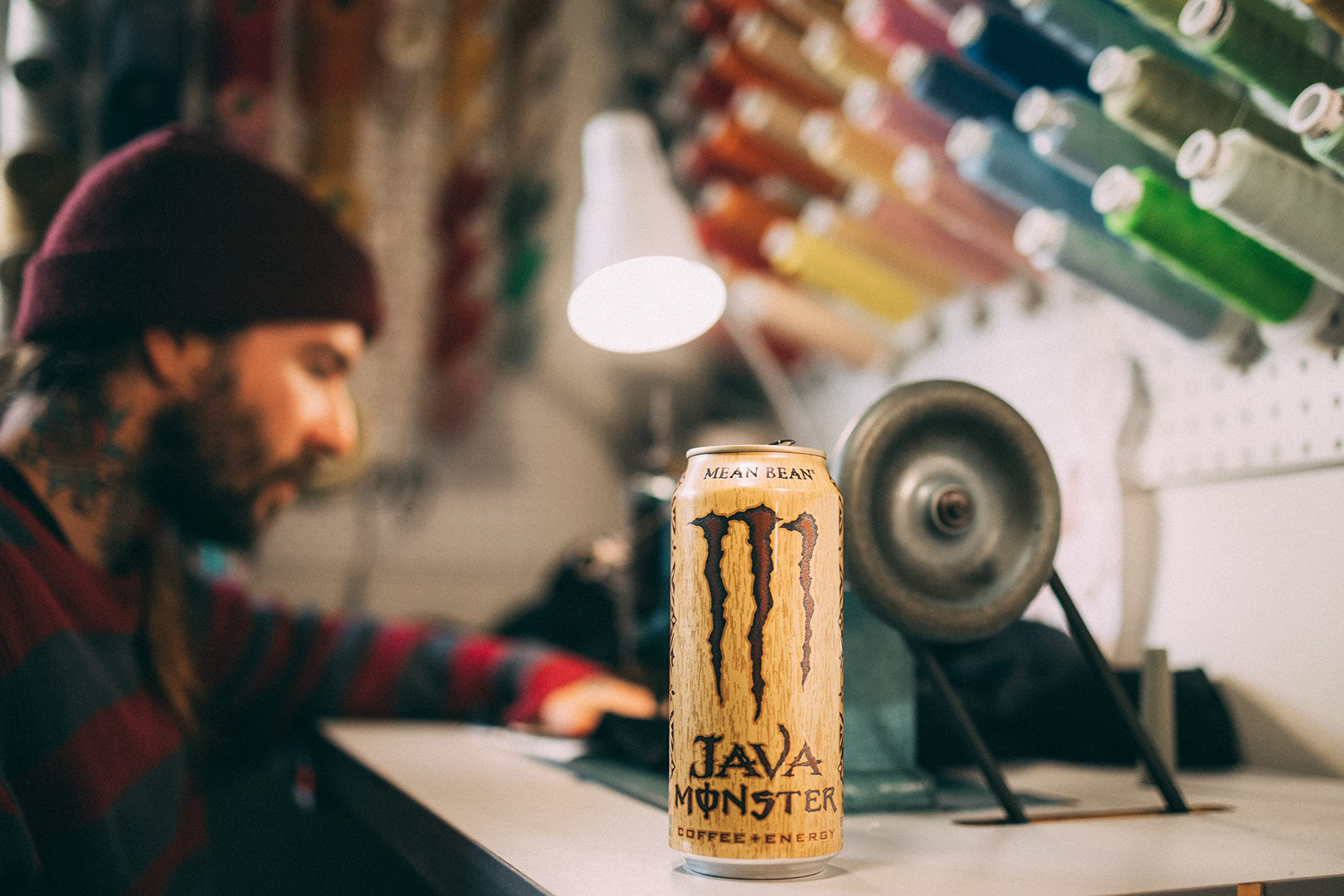 Monster escena lifestyle con lata sobre mesa como sustituto de café de cafetería