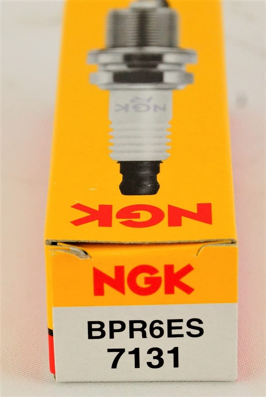 NGK BPR6ES en taller con herramientas, listo para reemplazo práctico
