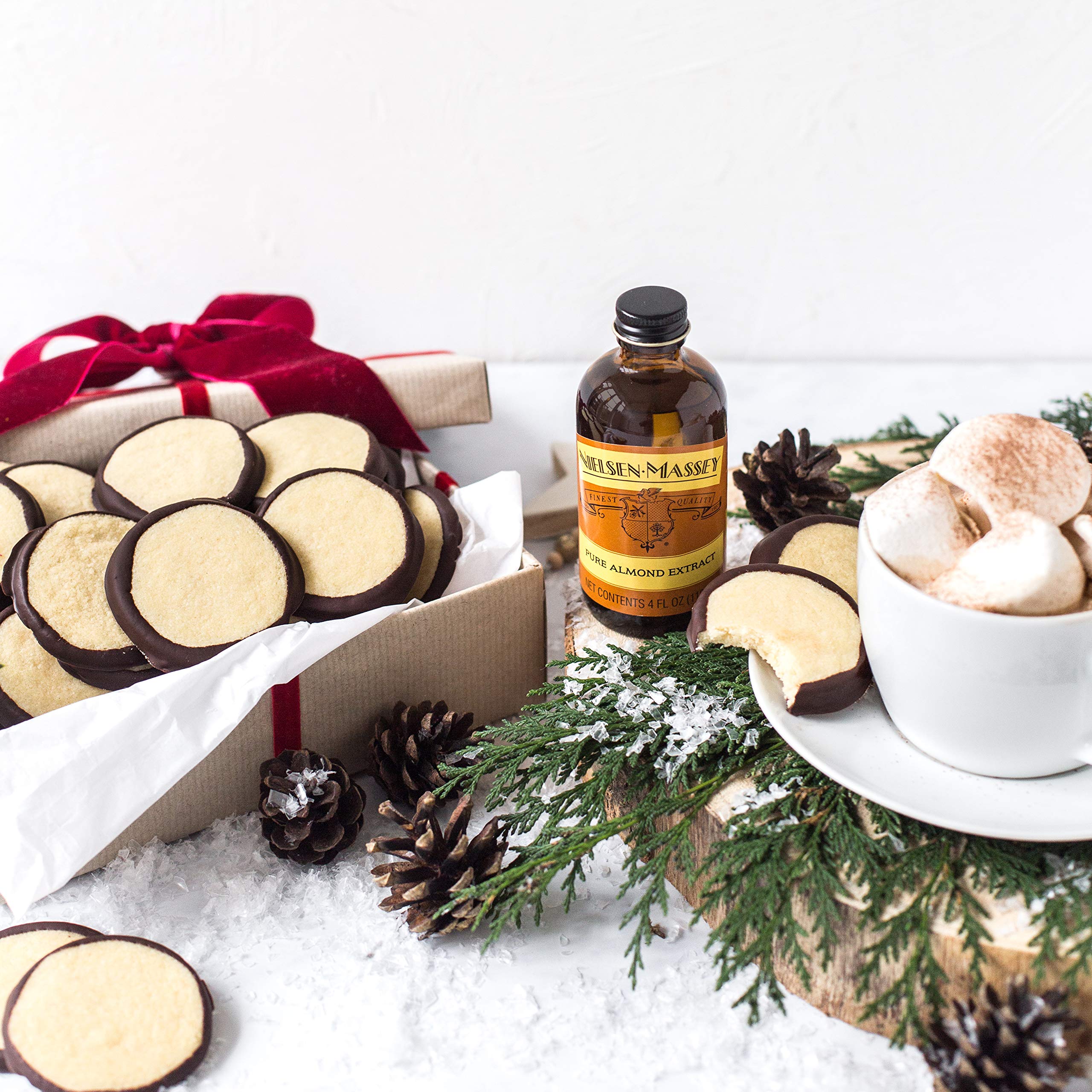 Nielsen-Massey botella junto a masa de galletas demostrando uso práctico en repostería