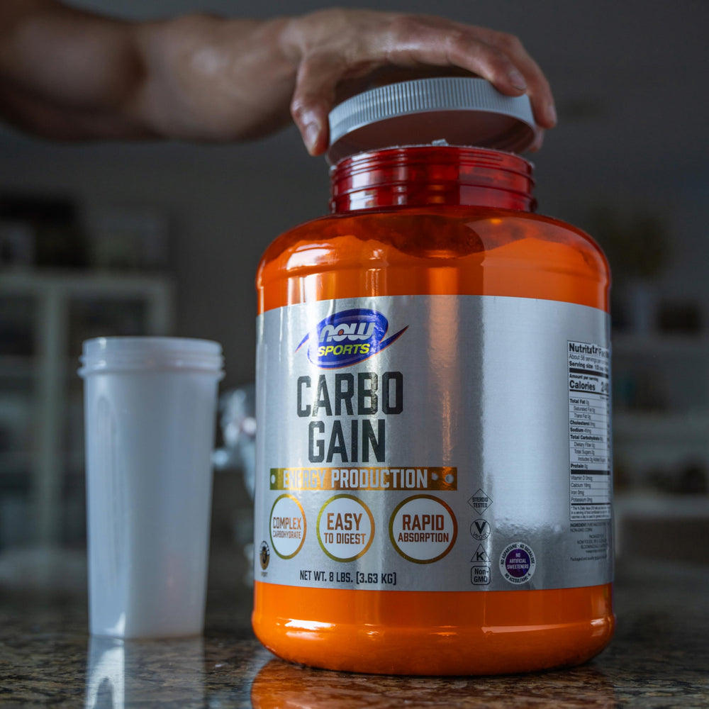 Atleta usando bebida con NOW Foods Carbo Gain durante entrenamiento intenso