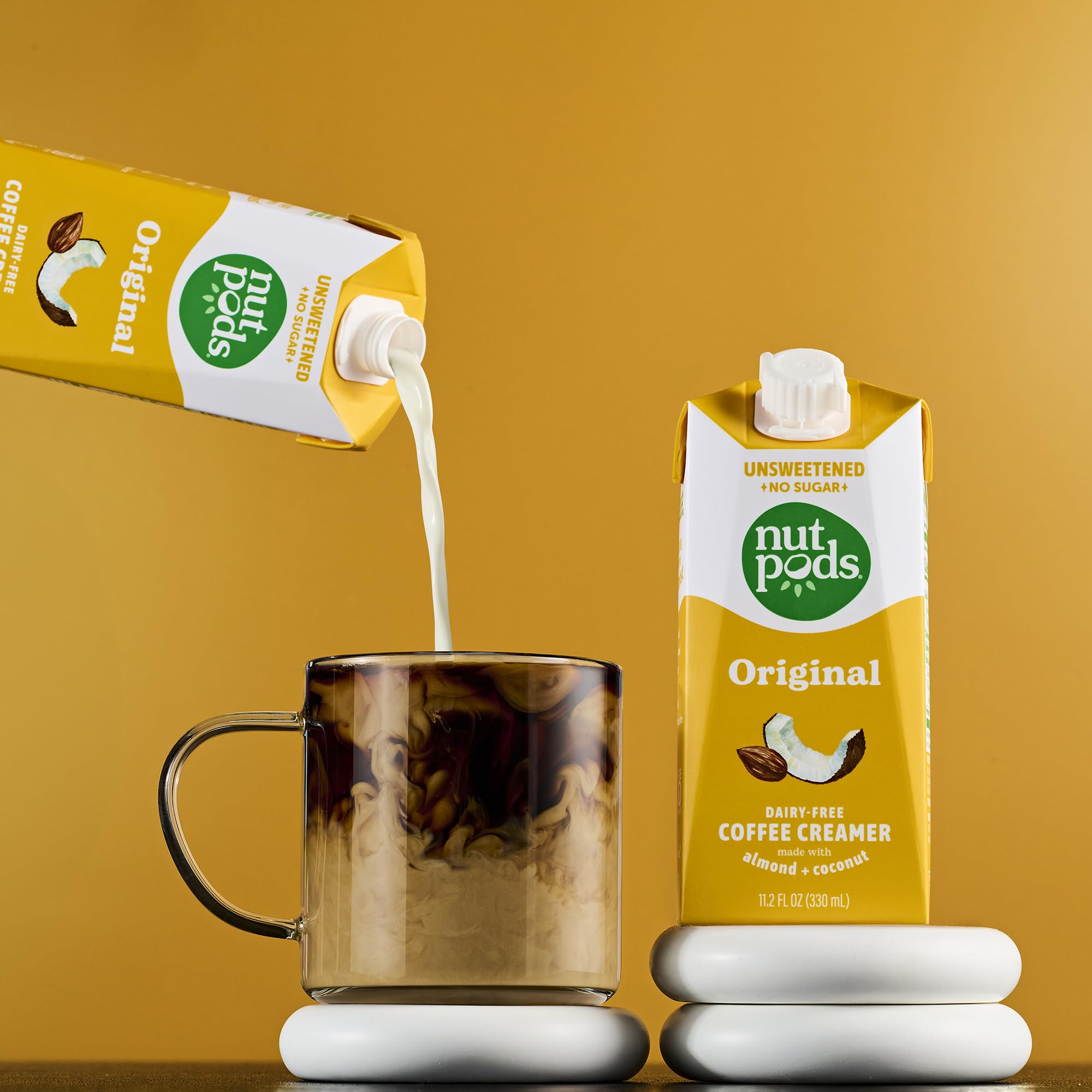 nutpods envase en mano para comparar tamaño, práctico y portable