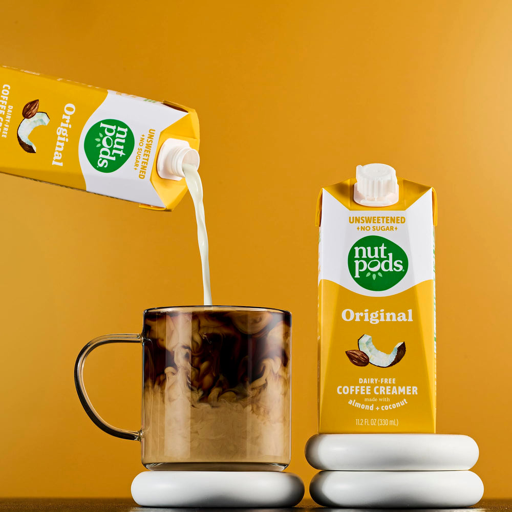 nutpods envase en mano para comparar tamaño, práctico y portable