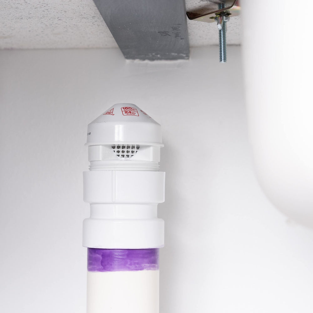 Oatey válvula instalada bajo lavabo demostrando ventilación secundaria