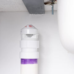 Oatey válvula instalada bajo lavabo demostrando ventilación secundaria