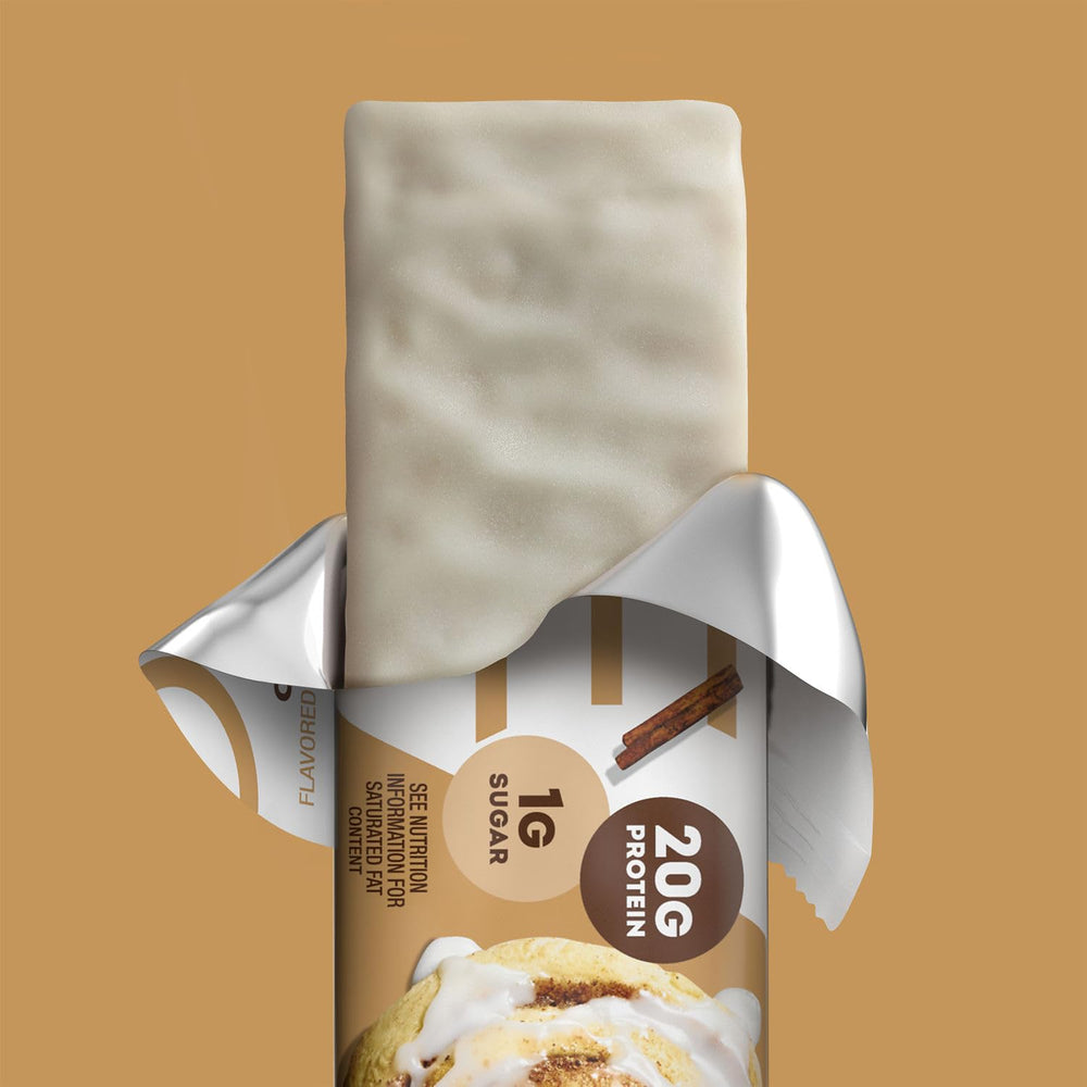 ONE barra Cinnamon Roll en mano como snack práctico tras entrenar